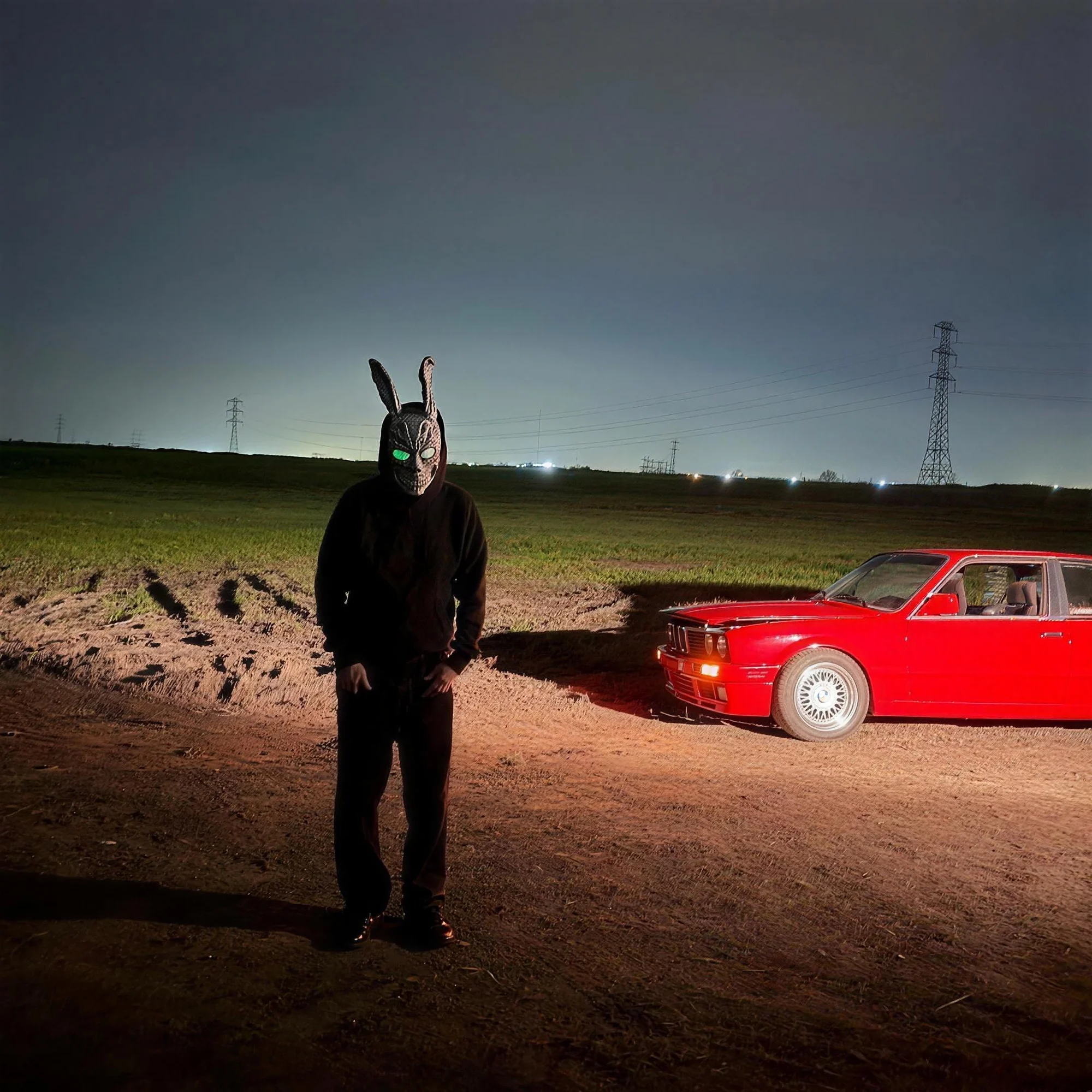 Nickla 12 con la máscara de Donnie Darko junto a un auto rojo